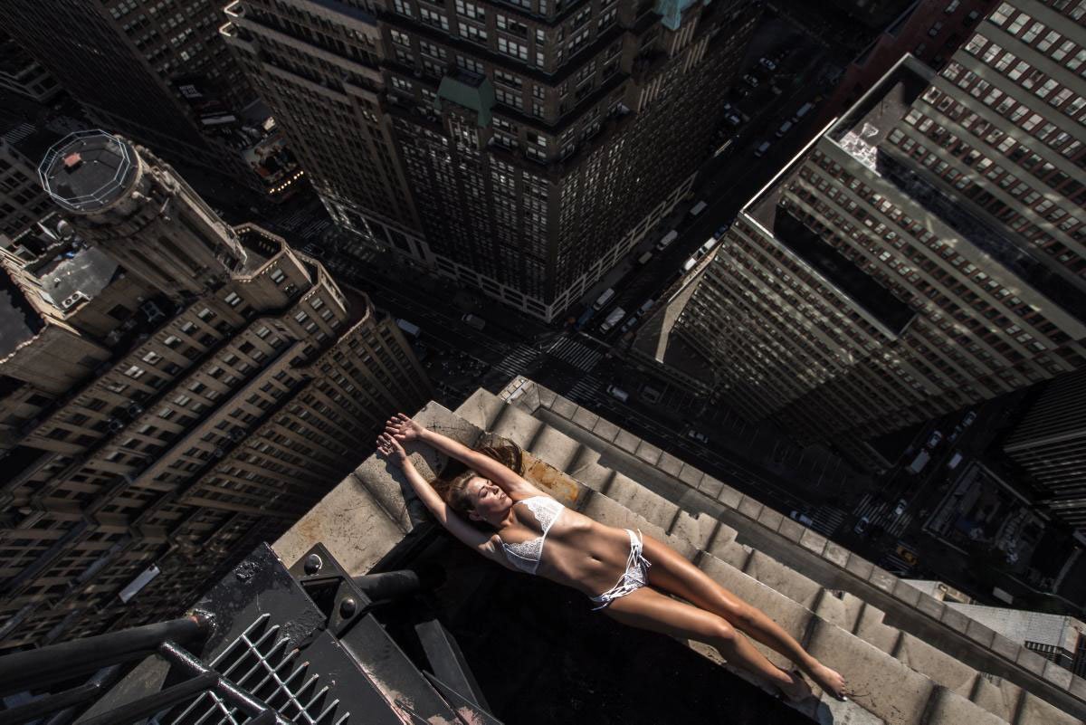 Обнаженная худая девушка взобралась на крышу многоэтажки